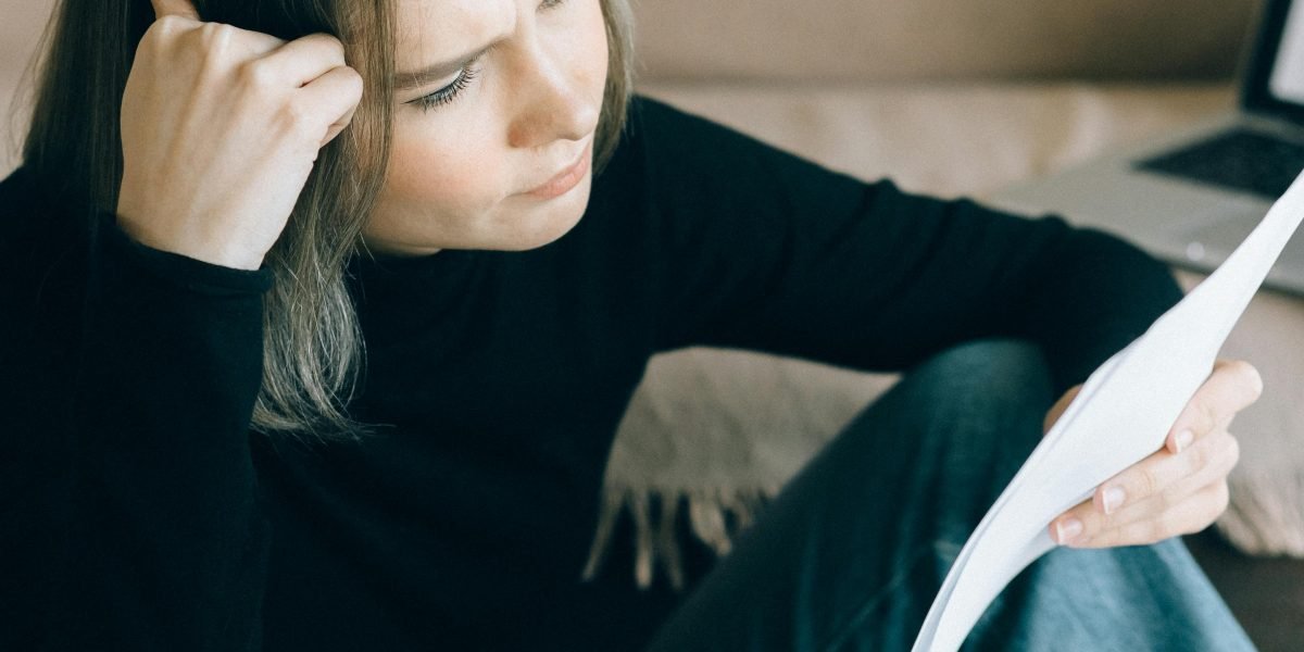 A person engaged in reading, reflecting on complex information to gain deeper understanding.