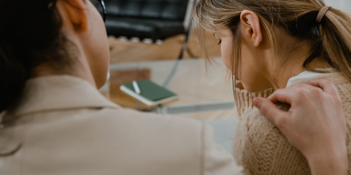 A therapist and client engaged in a supportive, trauma-informed therapy session.