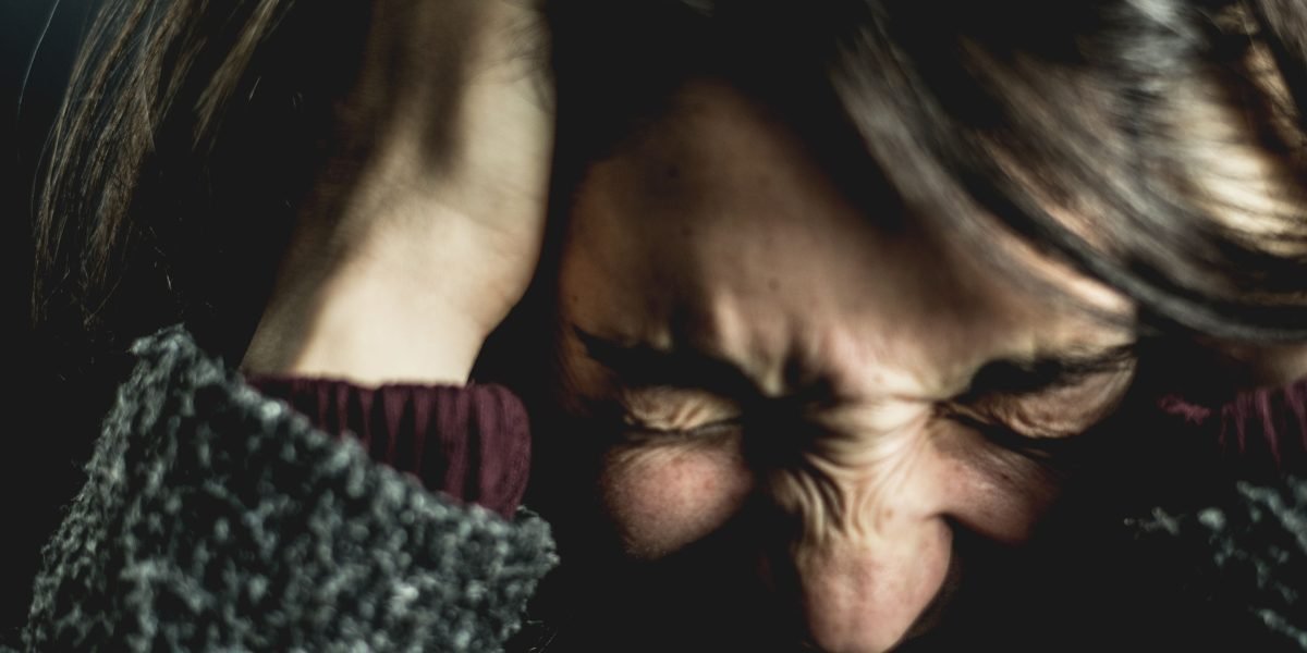 A person experiencing the physical manifestation of emotional stress, reflecting the mind-body link.