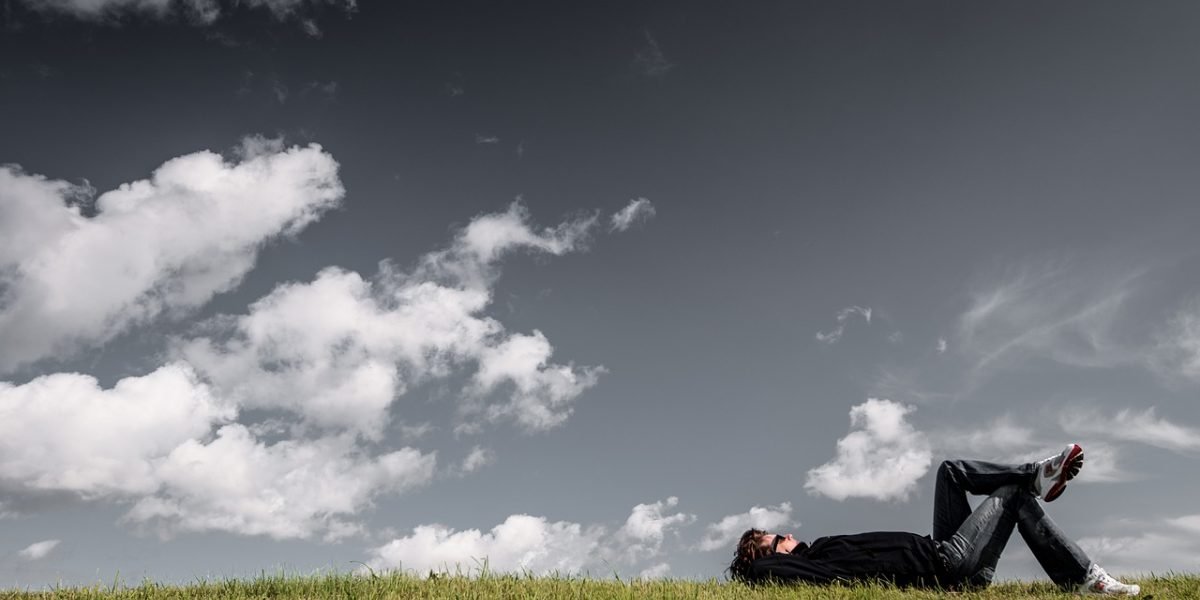 A person lying awake in bed in the dark, indicating a racing mind and inability to sleep due to worry.