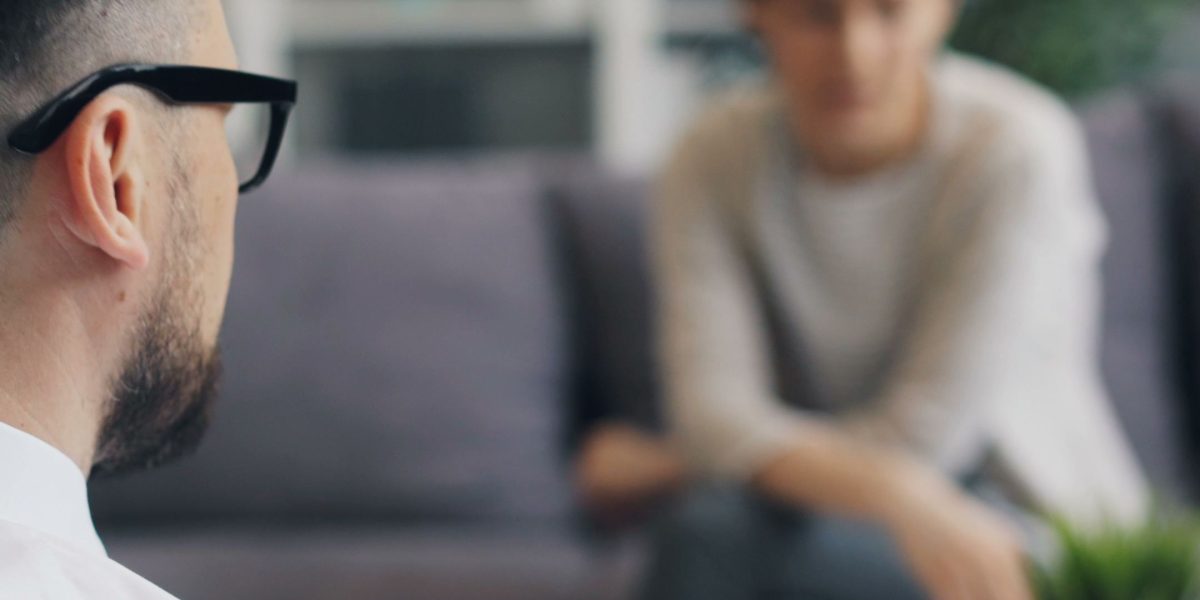 A person appearing isolated or unheard during a group conversation, representing the impact of a lack of empathy.