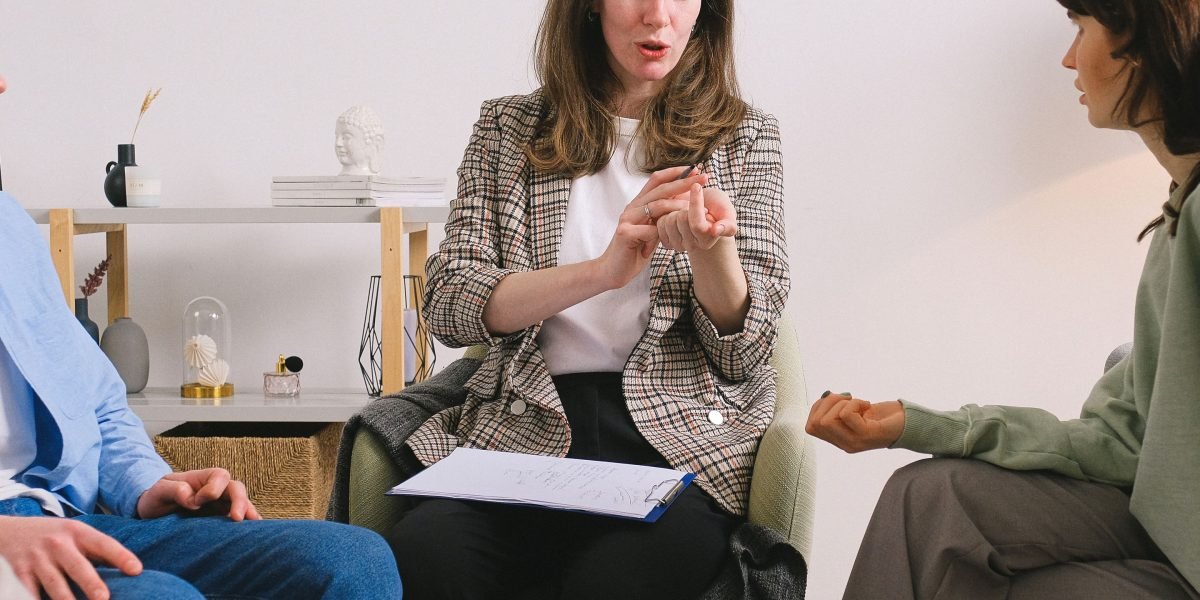 A therapist facilitating a group discussion with a family, observing their interactions to guide towards healthier patterns.