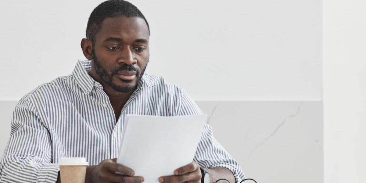 A person thoughtfully reviewing documents, symbolizing the careful evaluation needed for CE courses.